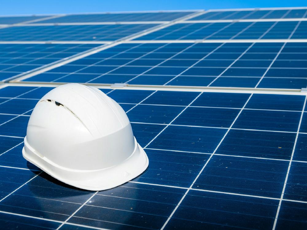 hard hat on top of solar panel