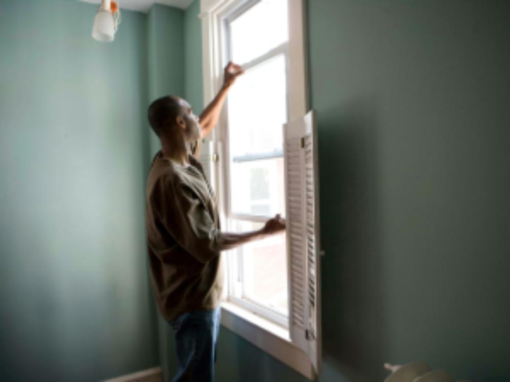 Man opening window indoors